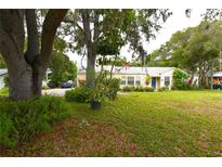 Charming one-story home featuring a well-manicured lawn and mature trees providing ample shade at 1372 Palmetto St, Clearwater, FL 33755