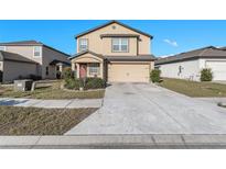 Charming two-story home featuring a two car garage, and well-maintained landscaping under a clear blue sky at 14269 Lemon Yellow Tree Ln, Brooksville, FL 34613