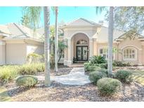 Elegant home exterior showcasing a tile roof, landscaped yard and double doors at 16331 Burniston Dr, Tampa, FL 33647