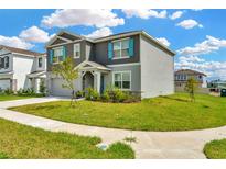 Beautiful two-story home features blue shutters, stone accents, and a well-maintained lawn in a Gathering-friendly neighborhood at 31818 Treasure Dock Isle, Wesley Chapel, FL 33545