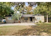 Charming single-story home with a well-manicured lawn, concrete driveway, and decorative palm trees at 6223 Bayshore Blvd, Tampa, FL 33611
