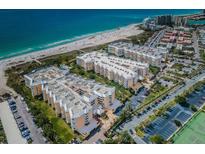 Expansive aerial view of the beachfront condominium complex with lush landscaping, parking, and beach access at 6500 Sunset Way # 202, St Pete Beach, FL 33706