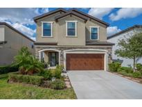 Charming two-story home boasts stone accents, a spacious driveway, and a well-manicured front yard at 12515 Horseshoe Bend Dr, Lithia, FL 33547