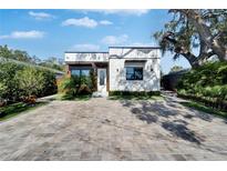 Charming home featuring modern brickwork, wood accents, neat landscaping, and a stylish brick driveway at 3106 Lila St, Tampa, FL 33610