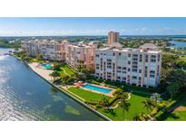 Stunning aerial view of waterfront condos with lush landscaping and pool overlooking beautiful blue waters at 4951 Bacopa S Ln # 103, St Petersburg, FL 33715