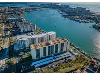 Expansive aerial view showcasing waterfront condos with boat docks, coastal city and sparkling water at 690 Island Way # 404, Clearwater Beach, FL 33767
