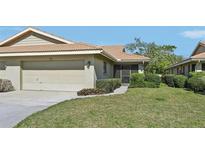 Charming one-story home with a well-maintained lawn, beige exterior, and an attached two-car garage at 7245 Wood Creek Dr # 29, Sarasota, FL 34231