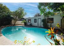 Inviting backyard pool with lush landscaping and a sunny patio area, perfect for relaxation and outdoor enjoyment at 810 E Baker St, Tampa, FL 33603