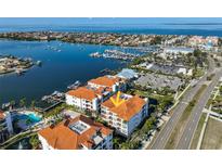 Stunning aerial view of waterfront condos with boat docks, city skyline, and a bright blue ocean backdrop at 1030 Bellasol Way # 302, Apollo Beach, FL 33572