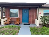 Inviting brick front porch featuring a blue door, two wooden chairs, and a small table at 24862 Us Highway 19 N # 3001, Clearwater, FL 33763