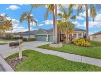 Charming home featuring a well-manicured lawn, mature landscaping, and a three-car garage at 3339 Brenford Pl, Land O Lakes, FL 34638
