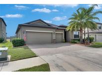 Charming single Gathering home showcasing a three-car garage, well-kept lawn, and beautiful palm trees at 10019 Celtic Ash Dr, Ruskin, FL 33573