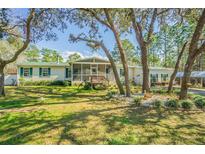 Charming single story home with screened porch, green shutters and well maintained landscaping at 17480 Nuthatch Rd, Weeki Wachee, FL 34614