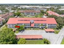 Aerial view of condominium building featuring covered parking and well-maintained landscaping at 2583 Countryside Blvd # 3212, Clearwater, FL 33761