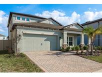 Charming two-story home with a brick driveway and attached two car garage at 3042 Marine Grass Dr, Wimauma, FL 33598