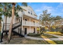 Beautiful exterior view of a multi-story building with balconies, black steel stairs, and mature trees in a well-maintained community at 3300 Haviland Ct # 304, Palm Harbor, FL 34684