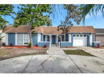 Charming one-story home with a two-car garage, featuring a well-maintained yard with mature trees and landscaping at 3544 Landale Dr, Holiday, FL 34691