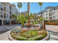 Beautiful condo entrance featuring a fountain, lush landscaping, and a well-maintained exterior at 501 Knights Run Ave # 1203, Tampa, FL 33602