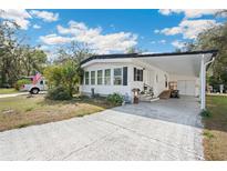 Charming single-story home with carport, manicured lawn, and well-lit driveway at 5125 Jo St, Zephyrhills, FL 33542