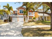 Beautiful two-story home featuring a two-car garage, well-manicured lawn, and tropical palm trees at 6411 Grenada Island Ave, Apollo Beach, FL 33572