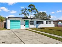 Charming single-story home with a well-manicured lawn and a bright blue door and garage at 6681 32Nd N Ave, St Petersburg, FL 33710