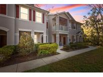 Charming townhome featuring red shutters, a private balcony, and well-maintained landscaping at 9510 Georgian Park Ln # 106, Tampa, FL 33626