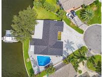 Aerial view of renovated home and pool on waterfront property with dock and lush tropical landscaping at 1514 Sea Gull S Dr, St Petersburg, FL 33707