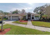 Charming single-story home featuring a three-car garage, lush landscaping, and a well-manicured lawn at 3037 Crest Dr, Clearwater, FL 33759