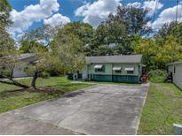 Charming single-story home with a spacious driveway and a large, shady tree in the front yard at 5504 60Th N Way, St Petersburg, FL 33709