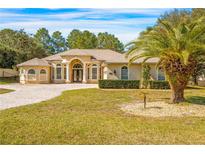 Stunning one-story home with a circular driveway and lush landscaping at 10159 Hernando Ridge Rd, Weeki Wachee, FL 34613