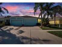 Charming single-story home with a two-car garage, lush landscaping, and a beautiful sky at 11542 Captiva Kay Dr, Riverview, FL 33569