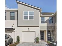 Modern townhouse featuring a two-car garage, clean architectural lines, and minimal landscaping at 25993 Woven Wicker Bnd, Lutz, FL 33559