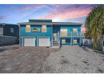 Charming blue two-story home with brick driveway and a white balcony in a beach community at 330 6Th Ave, Indian Rocks Beach, FL 33785