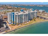 Wide aerial view of a beachfront apartment complex overlooking the water with well-maintained landscaping at 500 Treasure Island Cswy # 404, Treasure Island, FL 33706