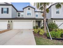 Two-story townhome with an attached garage and a well-manicured landscaped front yard at 6256 Shiner St, Land O Lakes, FL 34638