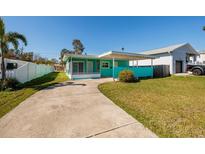 Charming turquoise home featuring a covered carport and spacious front yard with a long private driveway at 3774 Arkansas Ne Ave, St Petersburg, FL 33703