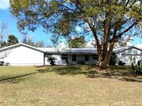 A single story home with an attached garage, a metal roof, and a well manicured lawn at 39349 & 39343 Rusbe Dr, Zephyrhills, FL 33540