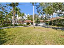Charming single story home with an arched entrance and a well maintained front yard surrounded by mature trees at 4609 W San Miguel St, Tampa, FL 33629