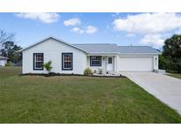 Charming home featuring a well-maintained lawn and a bright, freshly painted exterior at 6160 Van Dine St, Englewood, FL 34224