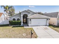 Charming single-story home with well-maintained lawn and attached two-car garage at 7911 Floradora Dr, New Port Richey, FL 34654