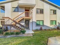 Two-story condo with a private entrance, brown stairs and landscaped green yard at 8024 Feather Ct # D, Hudson, FL 34667