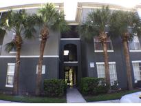 Three-story condo building with palm trees and well-maintained landscaping at 9404 Crescent Loop Cir # 104, Tampa, FL 33619