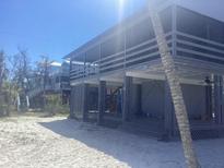 Beach house with a large, covered patio and stairs leading to the beach at 9620 Pieces Of Eight Trl, Placida, FL 33946