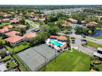 Community aerial showcasing tennis courts, pool, and lush landscaping at 1003 Hammock Pine Blvd # 1003, Clearwater, FL 33761