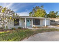 Charming single-story home with a bright teal front door, white columns, and a well-maintained front yard at 1859 Nevada Ne Ave, St Petersburg, FL 33703