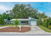 Charming single-story home featuring lush landscaping, a well-manicured yard, and a welcoming entrance at 2405 Indigo Dr, Clearwater, FL 33763