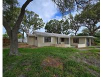 Charming single story home with a quaint front porch and mature trees in a partially overgrown yard at 53 Dolphin Dr # A, Treasure Island, FL 33706