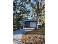 Charming single-story home with a brick facade and mature trees in a well-maintained yard at 1003 Engman St, Clearwater, FL 33755