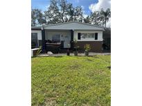 Modest single-story home with a simple front yard and mature trees providing shade at 2102 W Ivy St, Tampa, FL 33607