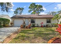 Charming single-story home with a well-manicured lawn, brick-lined walkway, and attached garage at 2940 Bay View Dr, Safety Harbor, FL 34695